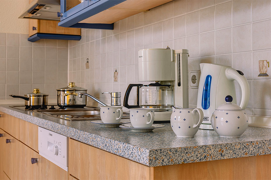 Beispiel Zweiraum-Wohnung: Küche mit Herd, Spülmaschine, Wasserkocher, Kaffeemaschine etc. 