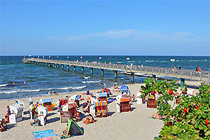 Strandkörbe am Strand neben der Seebrücke