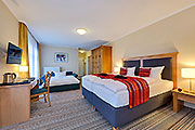 Hotelzimmer mit Doppelbett und Aufbettung